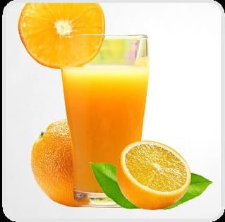 Copo alto de suco de laranja com uma rodela na borda e laranjas inteiras ao lado