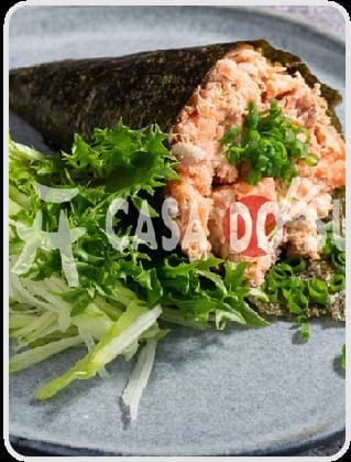 Cone de alga recheado de camarão desfiado com cebolinha, servido sobre folhas verdes